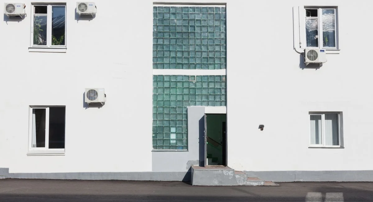 A contemporary building facade in Moscow with glass blocks and air conditioning units.