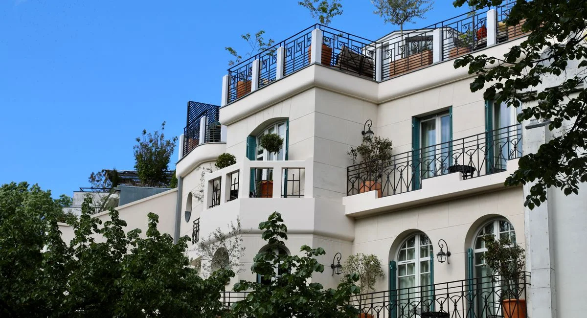 Charming Parisian apartment building with balconies set against a clear blue sky.
