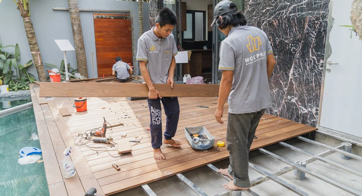 Carpenters working on a wooden floor installation in Hồ Chí Minh, Việt Nam.