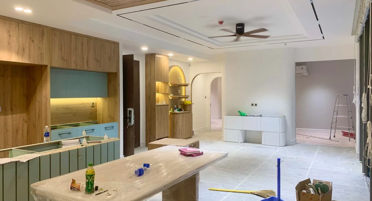 Spacious modern kitchen and dining area under renovation with wooden cupboards and stylish design.