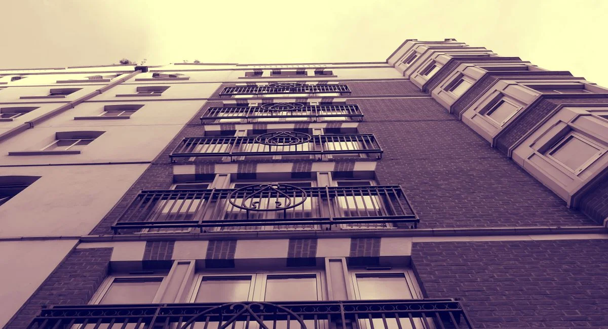 A sepia-toned low angle shot highlighting the design of a modern apartment building facade.