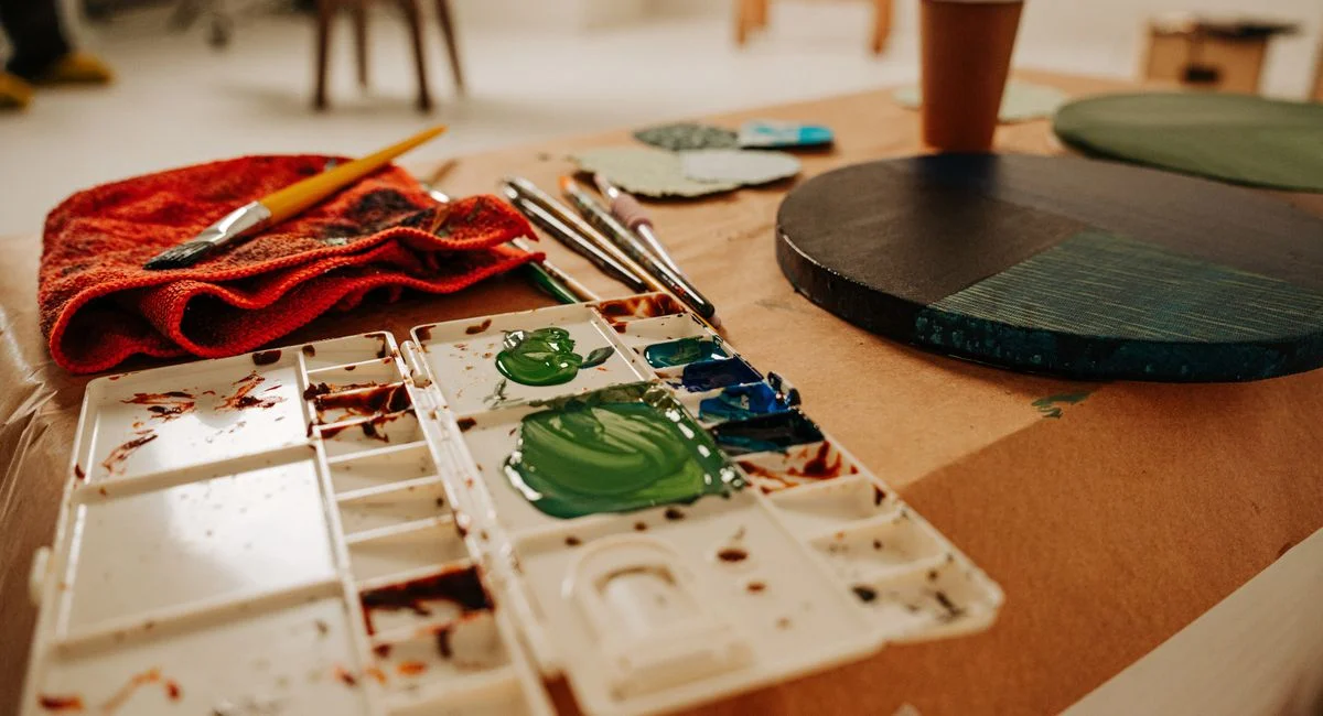 A creative workspace featuring paintbrushes, a palette, and artistic tools, ideal for inspiring art projects.