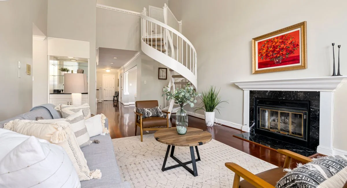 Modern living room with spiral staircase, fireplace, and stylish furnishings. Bright and inviting space for relaxation.
