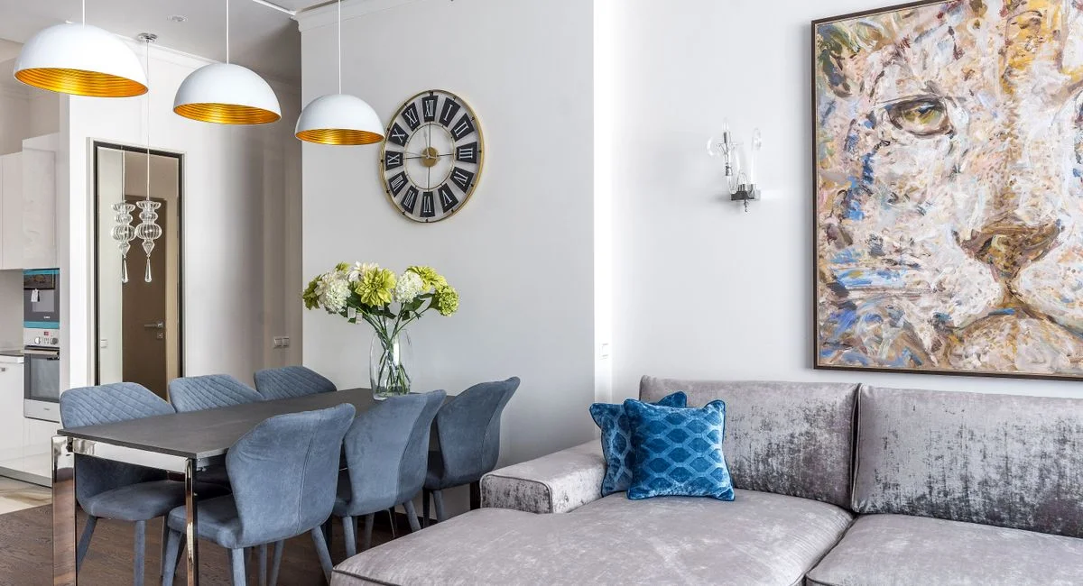 Interior design of cozy living room with comfortable sofa with cushions and table with flowers in vase in studio