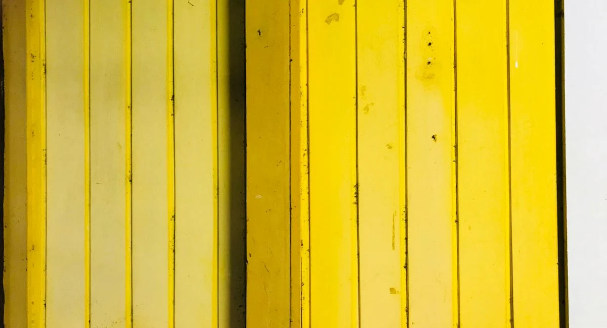 Textured yellow wooden door panels create a bold and vibrant look, perfect for design inspiration.