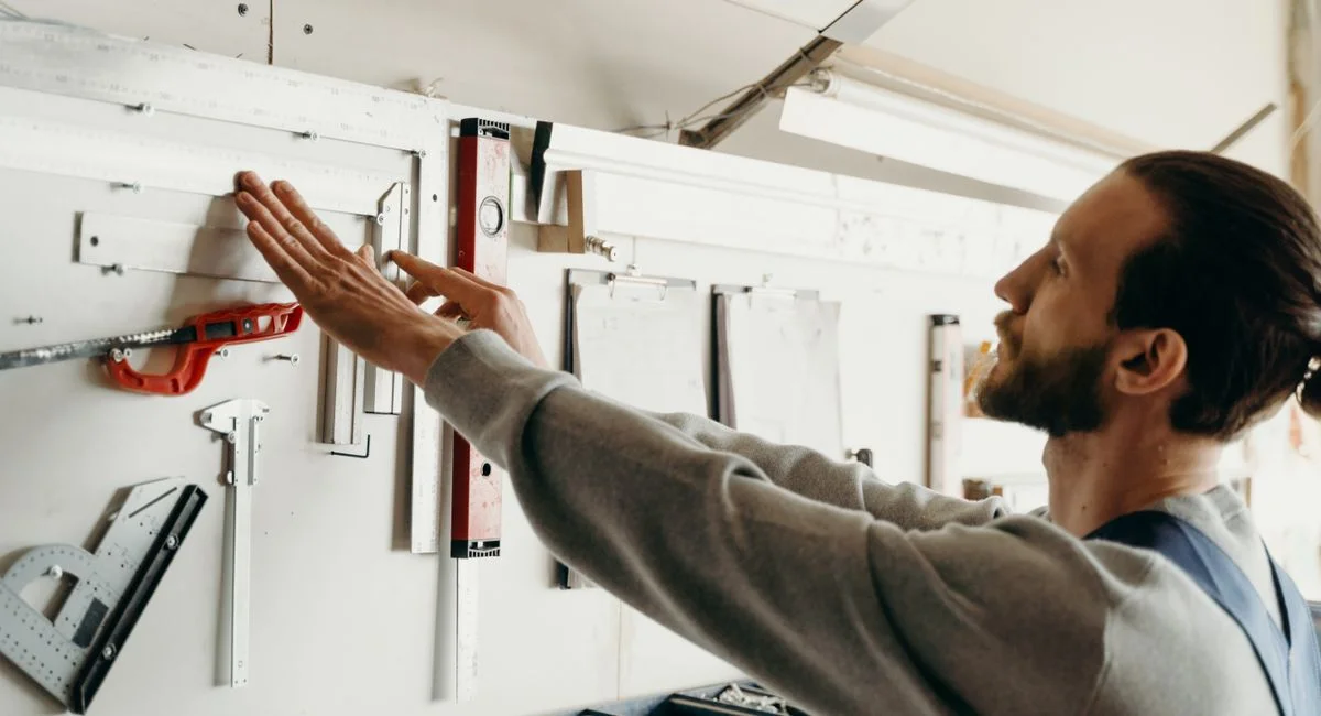 Focused woodworker arranging tools on a workbench, highlighting precision and craftsmanship.