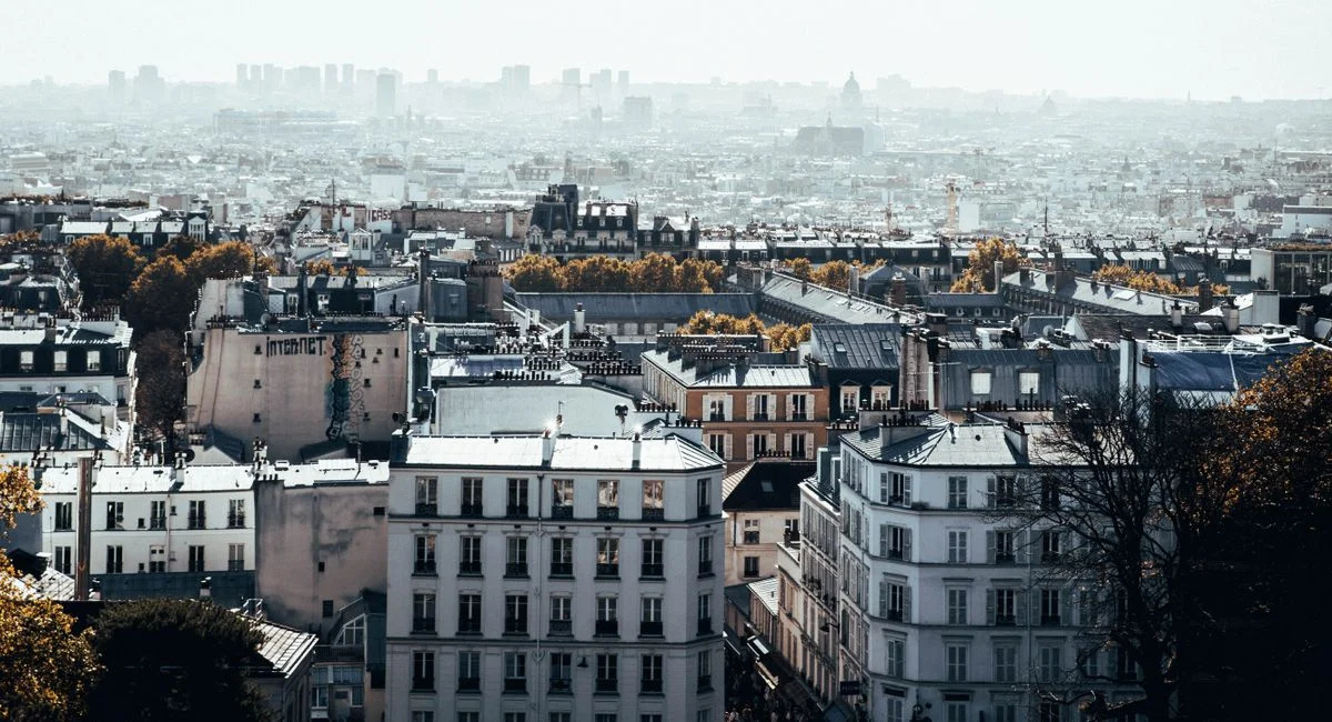 Aerial view of Paris with classic architecture under a hazy sky, capturing the city's charm.