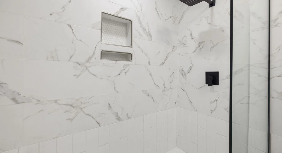 Sleek bathroom shower featuring marble tiles and black fixtures, perfect for modern luxury home design.