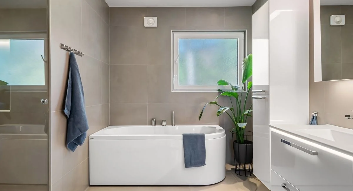 Minimalist bathroom featuring a white bathtub, sleek cabinetry, and modern fixtures.